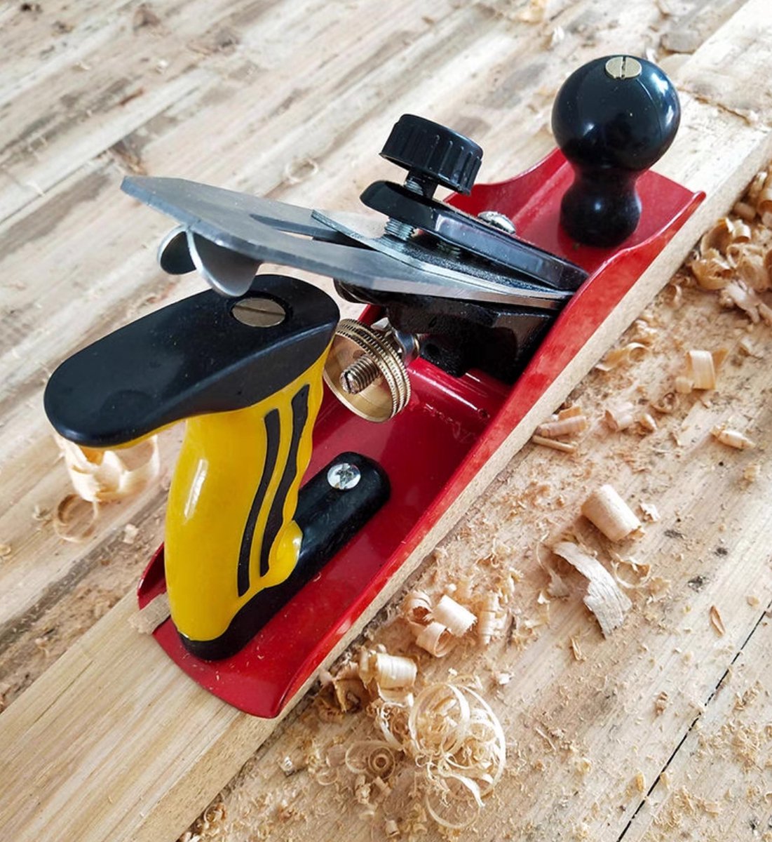 rabot à main métallique, souvent utilisé pour le travail du bois